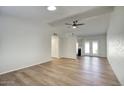 Bright living room with wood-look floors, ceiling fan, and access to the kitchen and patio at 1320 E Bethany Home Rd # 24, Phoenix, AZ 85014