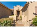 Welcoming front entrance with a gated courtyard and arched doorway at 16528 W Isleta Ct, Surprise, AZ 85387
