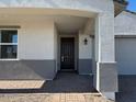 Inviting front entryway with a dark wood door and brick-paved porch at 17683 W Odeum Ln, Goodyear, AZ 85338