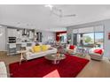 Bright, open-concept living room with hardwood floors, modern furniture, and seamless kitchen access at 18961 N 259Th Ave, Buckeye, AZ 85396