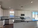 Modern kitchen featuring white cabinetry, black countertops, stainless steel appliances, and a subway tile backsplash at 19333 W Valle Vista Way, Litchfield Park, AZ 85340
