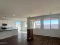 Open concept living room featuring wood-look tile floors and bright, natural light from large windows at 19333 W Valle Vista Way, Litchfield Park, AZ 85340