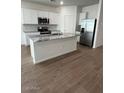 Modern kitchen featuring white cabinets, stainless steel appliances, and a center island at 25430 W Graham Trl, Buckeye, AZ 85326