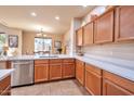 Kitchen with stainless steel appliances, wood cabinets, white countertops, and an adjacent dining area with lots of light at 3131 E Legacy Dr # 1104, Phoenix, AZ 85042