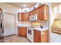 Bright kitchen featuring light wood cabinets, white countertops, and stainless steel appliances and staircase at 3131 E Legacy Dr # 1104, Phoenix, AZ 85042