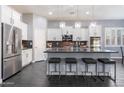 Gourmet kitchen features white cabinets, granite countertops, stainless steel appliances, an island, and modern lighting at 31660 N 130Th Ln, Peoria, AZ 85383