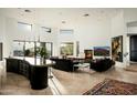 Open living room with fireplace, high ceilings, modern decor, and seamless transition to kitchen at 41688 N 111Th Pl, Scottsdale, AZ 85262