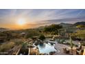 Desert home featuring a backyard pool, patio, and scenic mountain views at sunset at 41688 N 111Th Pl, Scottsdale, AZ 85262