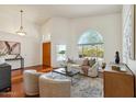 Bright living room with vaulted ceilings, hardwood floors, arched window and front entry door at 5310 W Melinda Ln, Glendale, AZ 85308