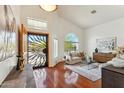 Bright living room with high ceilings, arched window, hardwood floors and decorative front door at 5310 W Melinda Ln, Glendale, AZ 85308