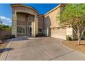 Two-story home featuring a large driveway, neutral stucco, and a two-car garage at 6838 W Lynne Ln, Laveen, AZ 85339