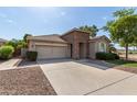 Inviting single-story home featuring a spacious driveway, a two-car garage, and desert landscaping at 6993 S Ruby Dr, Chandler, AZ 85249