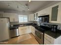 Modern kitchen with stainless steel appliances, white cabinetry, and granite countertops at 915 S Saranac Ave, Mesa, AZ 85208