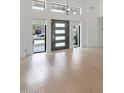 Bright foyer with hardwood floors, clerestory windows, and a modern entry door with sidelights at 10360 N 98Th St, Scottsdale, AZ 85258