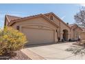 Close-up of a tan colored home with a wide two-car garage and desert-style landscaping at 11445 S 44Th St, Phoenix, AZ 85044