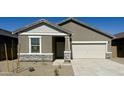 Single-story home with a two-car garage, a stone-accented facade, and low-maintenance desert landscaping at 13142 E Verbina Ln, Florence, AZ 85132