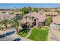 Stunning two-story home featuring well-kept lawn and mature palm tree at 1446 E Oxford Ln, Gilbert, AZ 85295