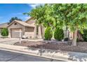 Lovely single-story home, a porch with mature trees, beautiful desert landscaping, and a two-car garage at 17620 W Weatherby Dr, Surprise, AZ 85374