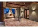 Covered patio featuring decorative fireplace, accent lighting and terracotta tile at 25002 N Quail Haven Dr, Rio Verde, AZ 85263