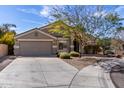 Inviting single-story home featuring a well-maintained lawn, desert landscaping, and a two-car garage at 2525 E Misty Willow Ln, Phoenix, AZ 85024