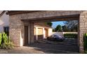 Modern garage featuring stone walls, wooden doors, and a beautiful sportscar on a paver driveway at 27864 N 158Th Ave, Surprise, AZ 85387