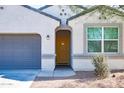 Close up of home featuring arched entry, desert landscaping, gray paint, and two car garage at 3029 S 78Th Dr, Phoenix, AZ 85043