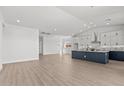 Open-concept kitchen featuring white cabinets, stainless steel appliances, and a contrasting navy blue island at 32489 N 135Th Dr, Peoria, AZ 85383