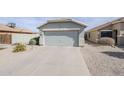 Attached two-car garage with a concrete driveway and low-maintenance landscaping at 39935 N Passaro Dr, San Tan Valley, AZ 85140