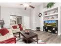 Bright living room featuring a ceiling fan, modern wood floors, and built-in shelving at 40656 N Key Ln, Anthem, AZ 85086