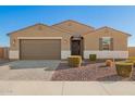 Welcoming single-story home with a two-car garage, enhanced by desert landscaping and a cozy front porch at 4459 E Warlander Ln, San Tan Valley, AZ 85140