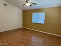 Bright bedroom with neutral walls, wood floors, a ceiling fan, and a large window at 614 W 7Th Ave, Mesa, AZ 85210