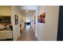 Long hallway with tiled floors, decorative wall art, and modern lighting fixtures at 6225 S Boulder St, Gilbert, AZ 85298