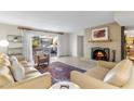 Bright living room with a brick fireplace, plush seating, and a sliding glass door to the backyard at 7912 E Plaza Ave, Scottsdale, AZ 85250