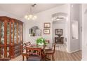 Charming dining area featuring wood-look floors, ornate china cabinet, and stylish lighting fixtures at 855 E Vaughn Ave, Gilbert, AZ 85234