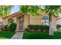 Inviting single-story home with arched windows, manicured bushes, and a secure front door entrance at 855 E Vaughn Ave, Gilbert, AZ 85234