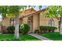 Welcoming single-story home features an arched entryway, neat landscaping, and a green lawn at 855 E Vaughn Ave, Gilbert, AZ 85234