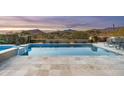 Sparkling pool with travertine tile and desert mountain views at 10238 E Rising Sun Dr, Scottsdale, AZ 85262