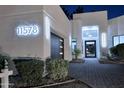 Modern home's exterior featuring illuminated address numbers, a black garage door, and a landscaped walkway at 11578 N 80Th Pl, Scottsdale, AZ 85260