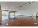 Spacious garage interior with painted floor and roll up door partially opened at 1373 E 23Rd Ave, Apache Junction, AZ 85119