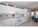 Bright kitchen with white cabinetry, complementing countertops, and views to the breakfast nook at 15779 W Remington Dr, Surprise, AZ 85374