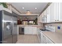 Well-appointed kitchen with stainless steel refrigerator, white cabinets, and an open layout at 15779 W Remington Dr, Surprise, AZ 85374