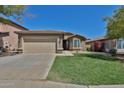 Inviting single-level home featuring a spacious two-car garage and verdant front lawn at 16188 W Hearn Rd, Surprise, AZ 85379