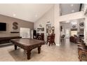 Spacious game room with vaulted ceilings, tile flooring, pool table, and bar seating at 16256 S 1St St, Phoenix, AZ 85048