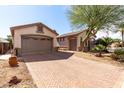 Long brick driveway leading to a two-car garage and a detached single car garage at 18261 W Weatherby Dr, Surprise, AZ 85374