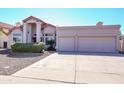 Inviting home exterior featuring a spacious driveway leading to a two-car garage and a meticulously kept front yard at 1915 E Citation Ln, Tempe, AZ 85284
