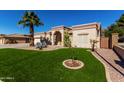 Lovely home with manicured lawn, desert plants, mature trees, and covered front entry at 20386 E Bronco Dr, Queen Creek, AZ 85142