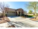 Inviting single-story home boasting a stone facade, two-car garage, and neatly landscaped front yard at 20421 W Legend Trl, Buckeye, AZ 85396