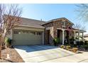 Attractive single-story home featuring a stone accent facade and a well-manicured front yard at 20421 W Legend Trl, Buckeye, AZ 85396