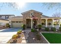 Charming single-story home with stone facade, covered porch, and well-maintained landscaping at 20421 W Legend Trl, Buckeye, AZ 85396