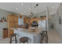Well-lit kitchen boasts ample wood cabinetry, modern stainless appliances, and a breakfast bar with seating at 2416 N Snead Dr, Mesa, AZ 85215